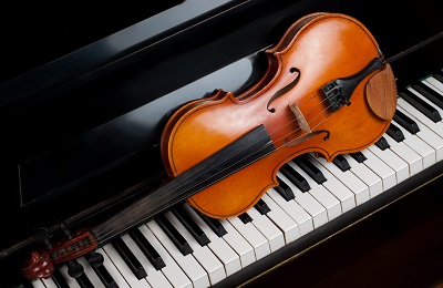 violin setting on top of a piano keys